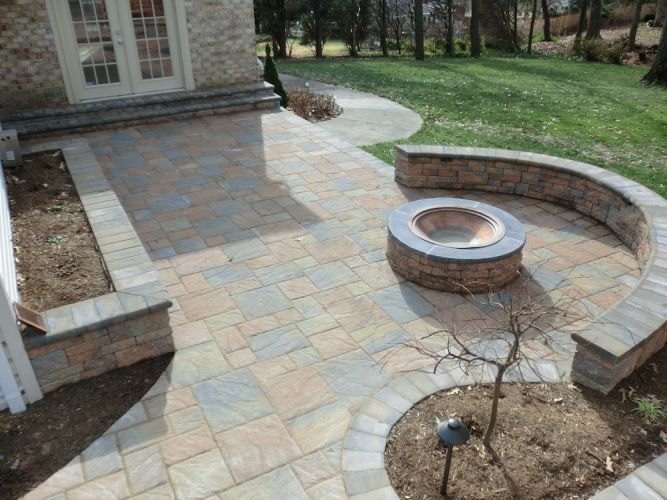 Out-door Patio with a stunning fire place, done with tiles by Top Choice Construction LLC